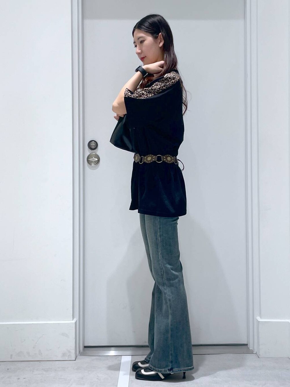 ブルー系のデニムパンツ、ブラック系のパンプス、ブラック系のショルダーバッグを着用したレディースの夏コーディネートの2枚目の写真