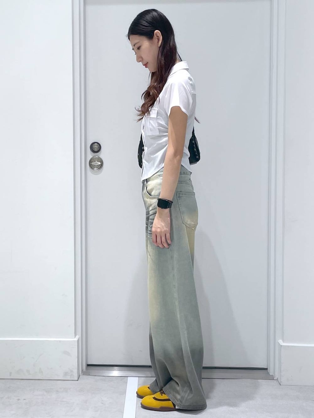 ホワイト系のシャツ/ブラウス、ブルー系のデニムパンツ、ブラウン系のハンドバッグを着用したレディースの夏コーディネートの2枚目の写真