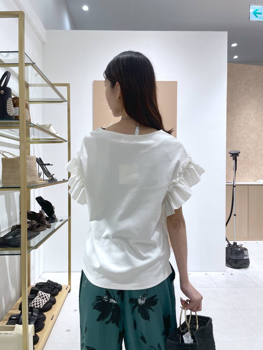グリーン系のその他パンツ、ブラック系のトートバッグ、ホワイト系のTシャツ/カットソーを着用したレディースの夏コーディネートの6枚目の写真
