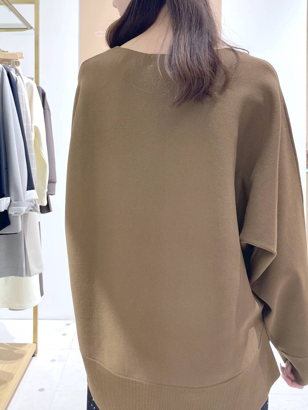 ブラック系のスカート、ブラック系のハンドバッグ、ブラウン系のニット/セーターを着用したレディースの春コーディネートの7枚目の写真