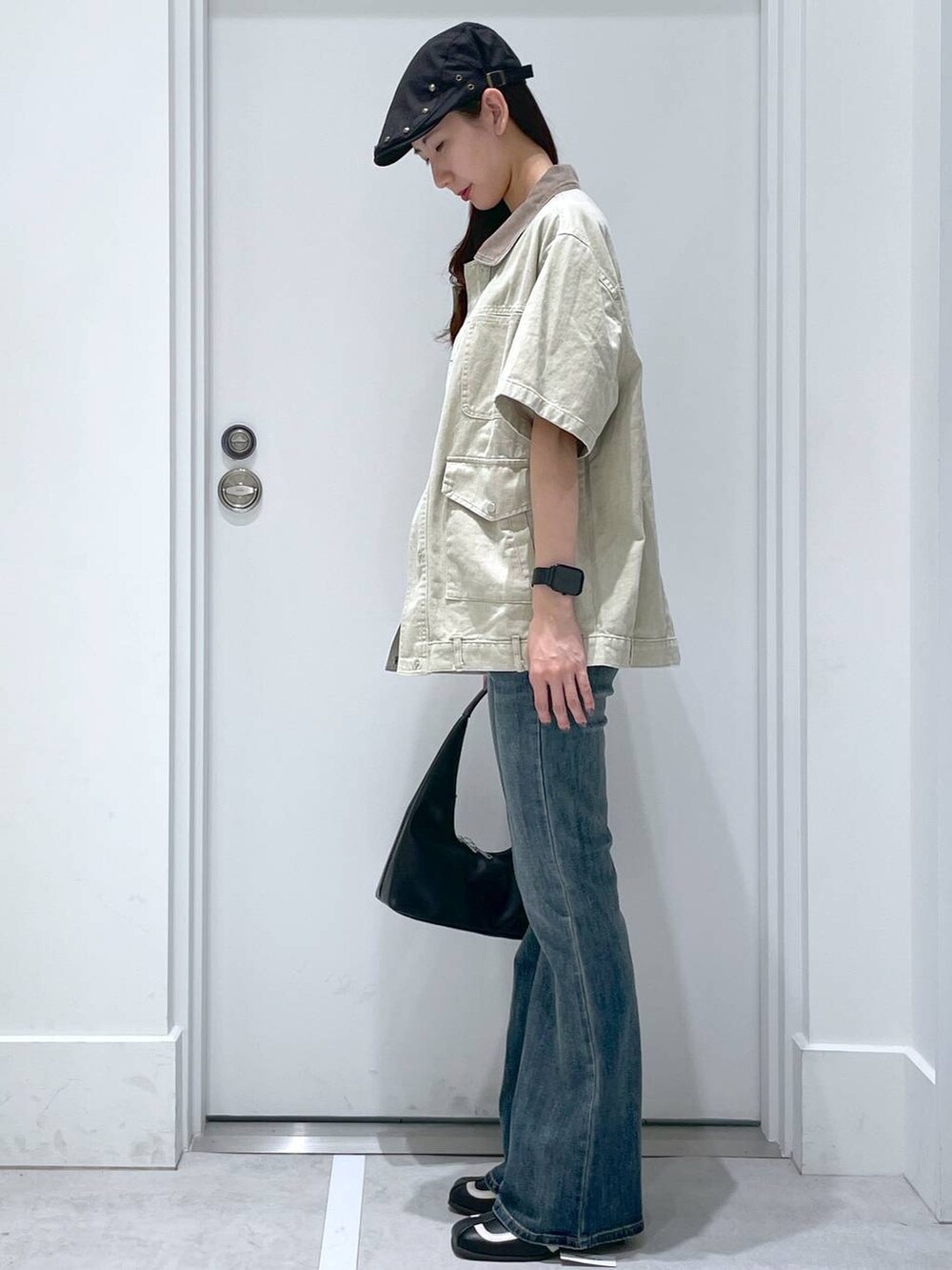 ブルー系のデニムパンツ、ブラック系のパンプス、ホワイト系のタンクトップを着用したレディースの夏コーディネートの2枚目の写真