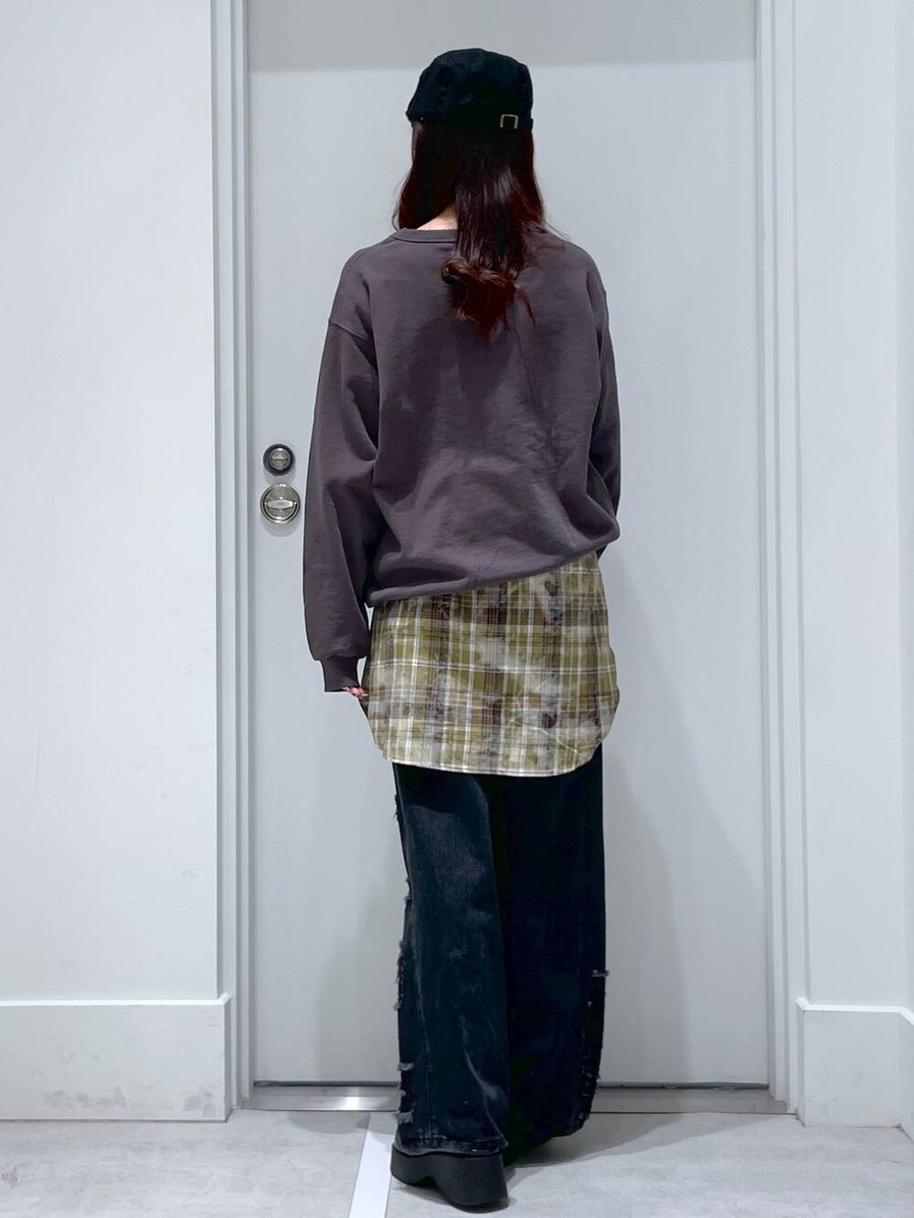 ホワイト系のハンドバッグ、ブラック系のスリッポン、ブラック系のデニムパンツを着用したレディースの冬コーディネートの3枚目の写真