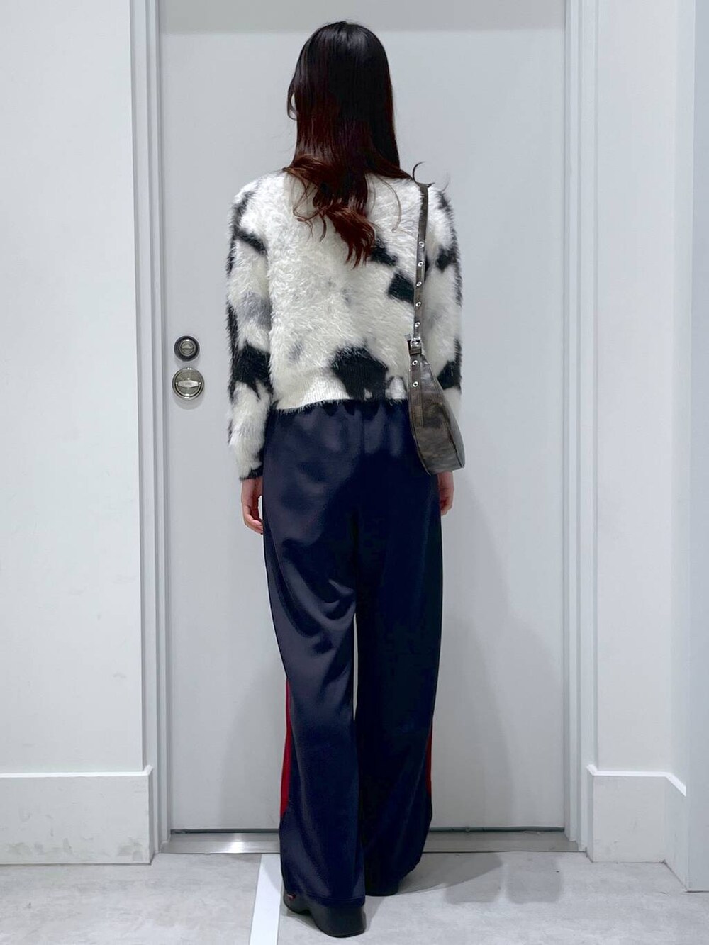 ホワイト系のスリッポン、ブルー系のその他パンツ、ベージュ系のカーディガン/ボレロを着用したレディースの冬コーディネートの3枚目の写真