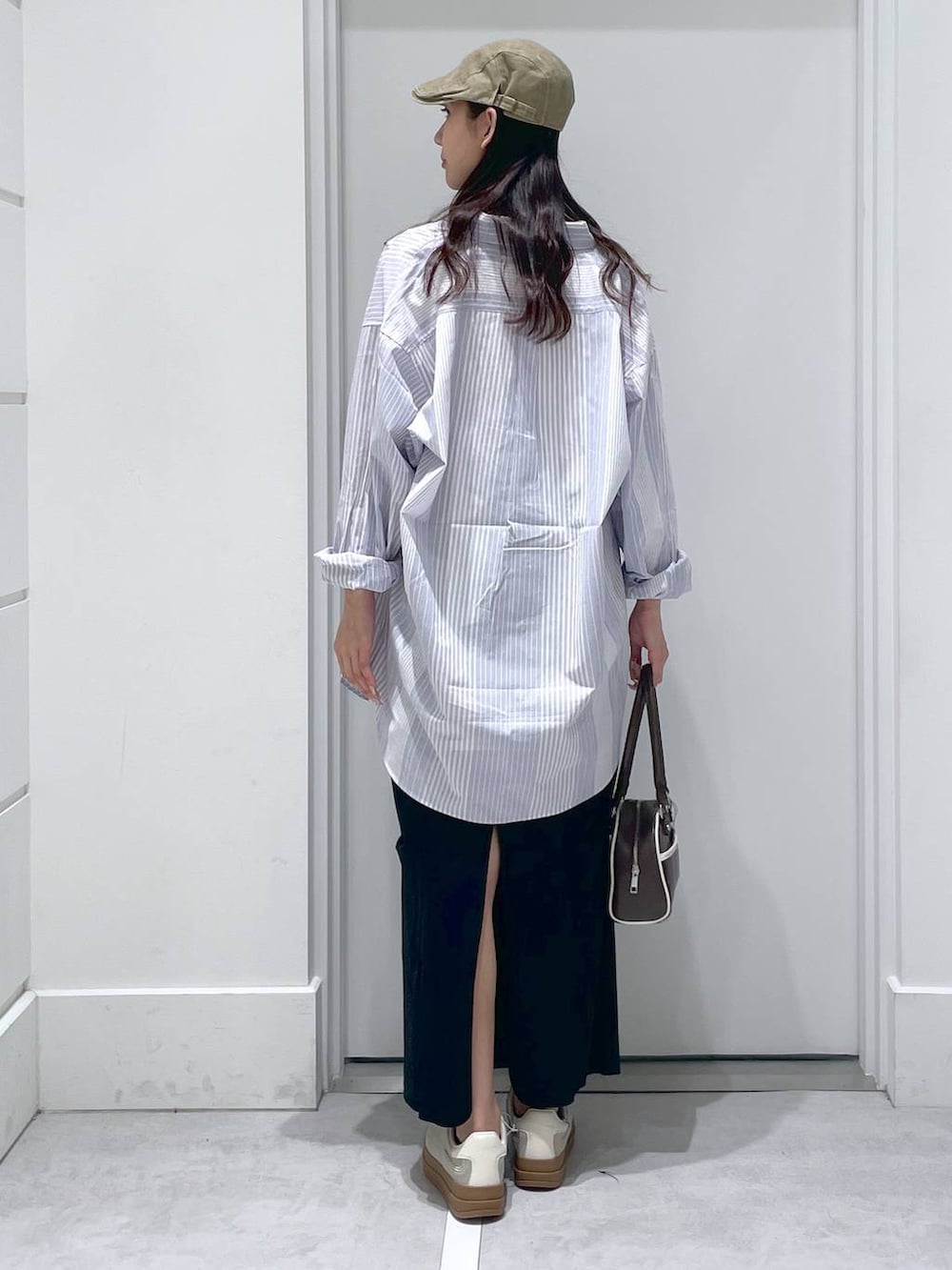 ブルー系のシャツ/ブラウス、ブラック系のスカート、ホワイト系のTシャツ/カットソーを着用したレディースの春コーディネートの3枚目の写真