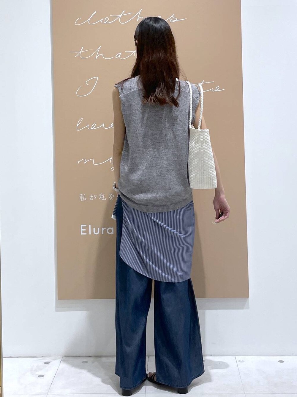 ブルー系のデニムパンツ、ブルー系のシャツ/ブラウス、ホワイト系のかごバッグを着用したレディースの夏コーディネートの3枚目の写真