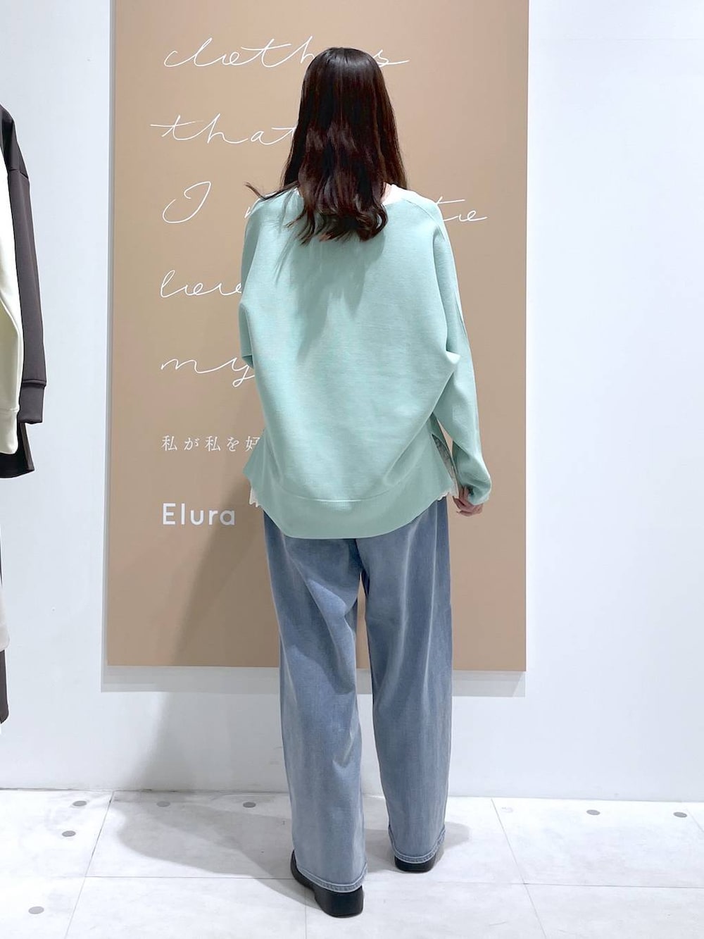 ホワイト系のタンクトップ、ブルー系のデニムパンツ、ブルー系のテーラードジャケットを着用したレディースの春コーディネートの6枚目の写真