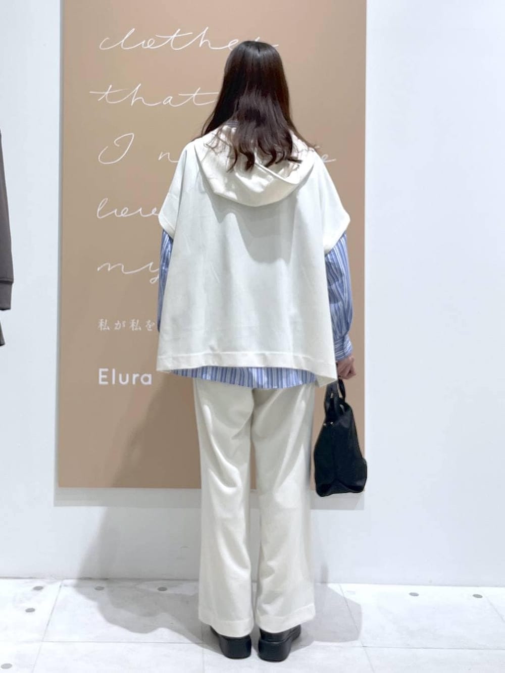 ホワイト系のその他パンツ、ブルー系のシャツ/ブラウス、ブラック系のショルダーバッグを着用したレディースの春コーディネートの3枚目の写真