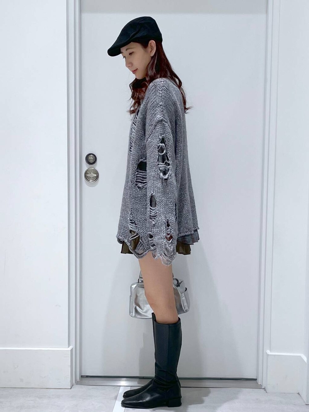 ブラウン系のシャツ/ブラウス、ブラウン系のスカート、グレー系のニット/セーターを着用したレディースの冬コーディネートの2枚目の写真