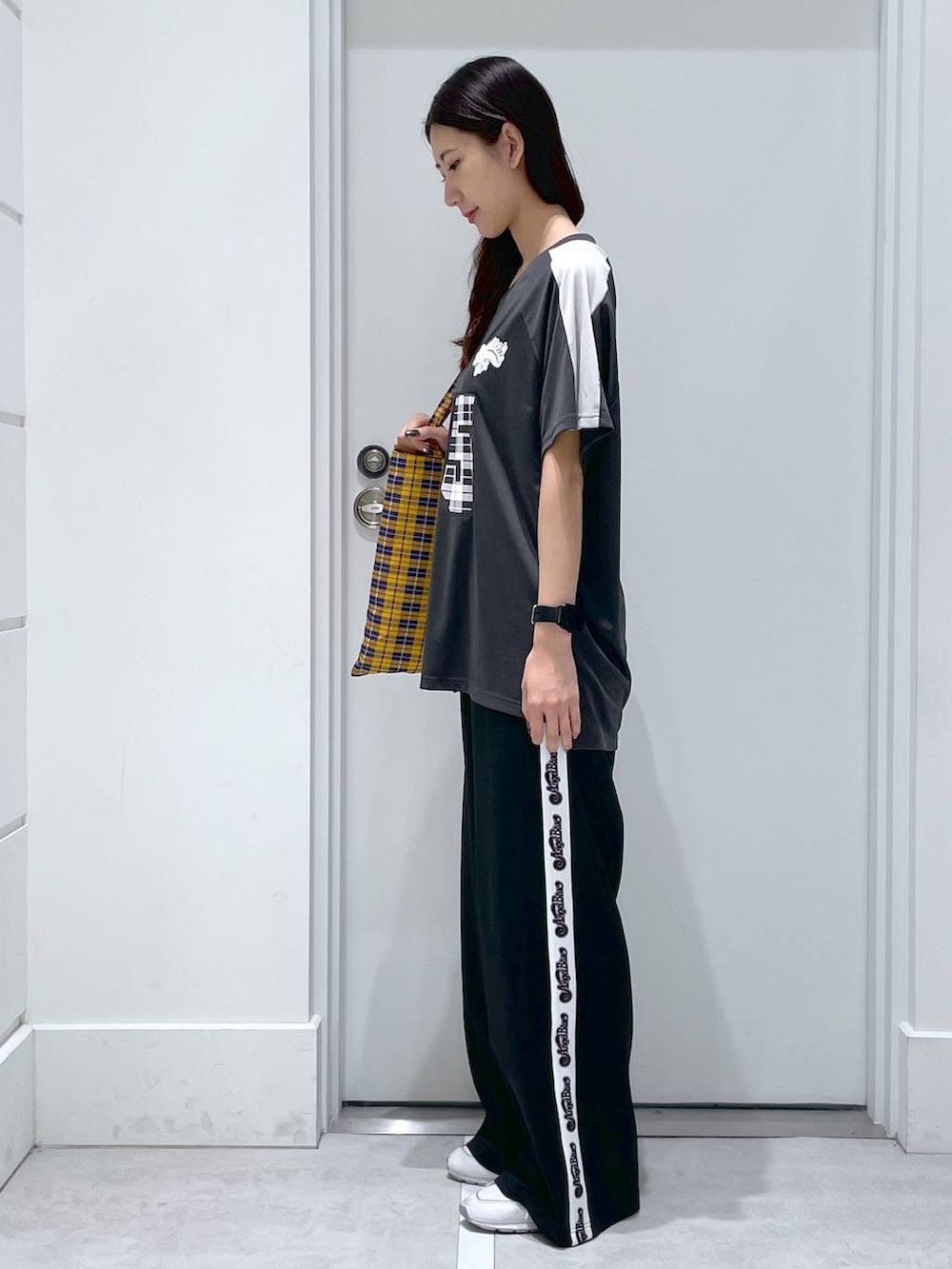 ブラック系のその他パンツ、ブラック系のTシャツ/カットソー、イエロー系のトートバッグを着用したレディースの春コーディネートの2枚目の写真