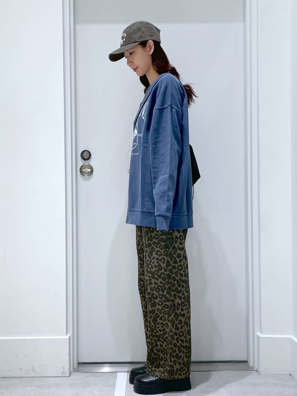 ブラック系のスリッポン、ブラック系のショルダーバッグ、ブルー系のスウェットを着用したレディースの冬コーディネートの2枚目の写真