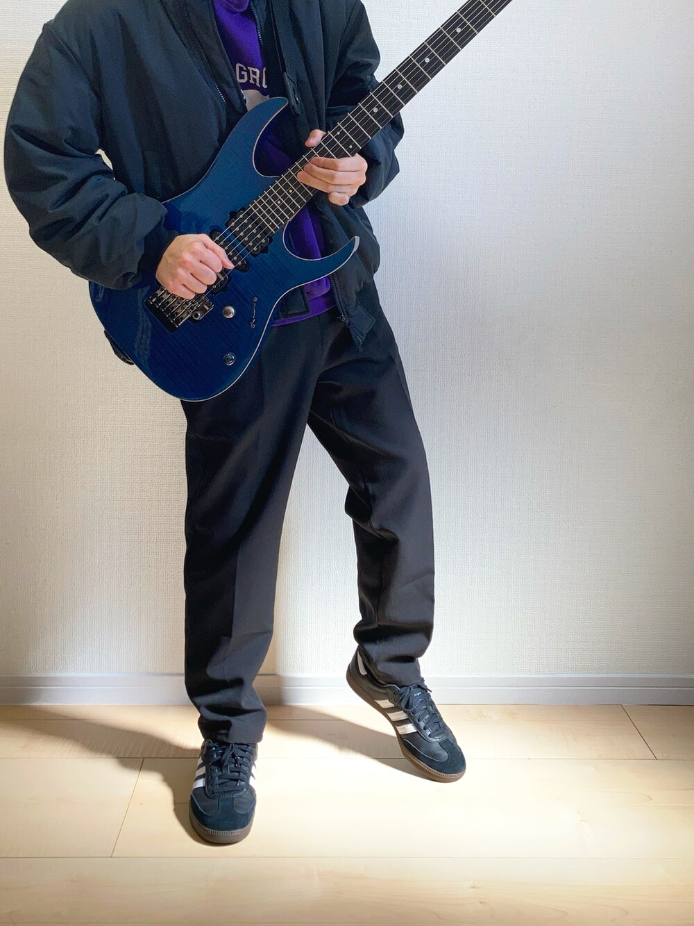 ブラック系のMA-1、ブラック系のスニーカー、ブラック系のスラックスを着用したメンズの春コーディネートの2枚目の写真