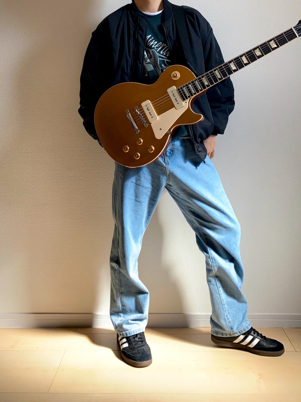 ブラック系のスニーカー、ブルー系のデニムパンツ、ブラック系のMA-1を着用したメンズの冬コーディネートの2枚目の写真