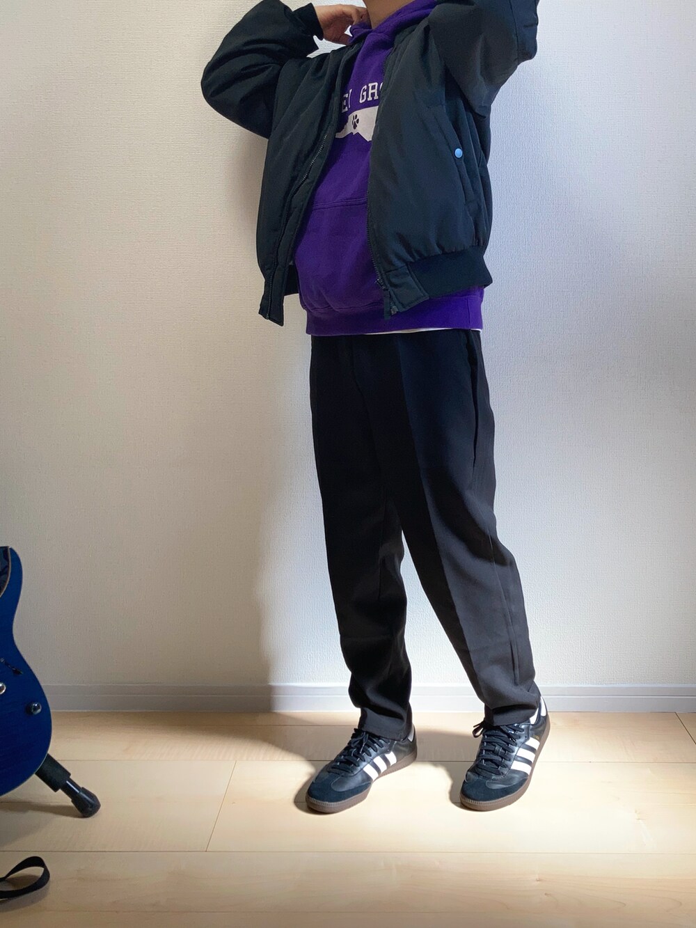 ブラック系のMA-1、ブラック系のスニーカー、ブラック系のスラックスを着用したメンズの春コーディネートの3枚目の写真