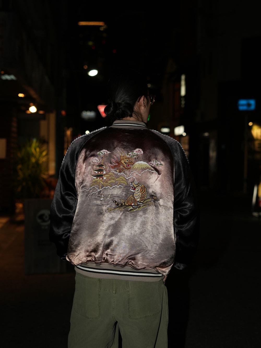 ブラウン系のスカジャン、ホワイト系のTシャツ/カットソー、グリーン系のカーゴパンツを着用したメンズの冬コーディネートの2枚目の写真