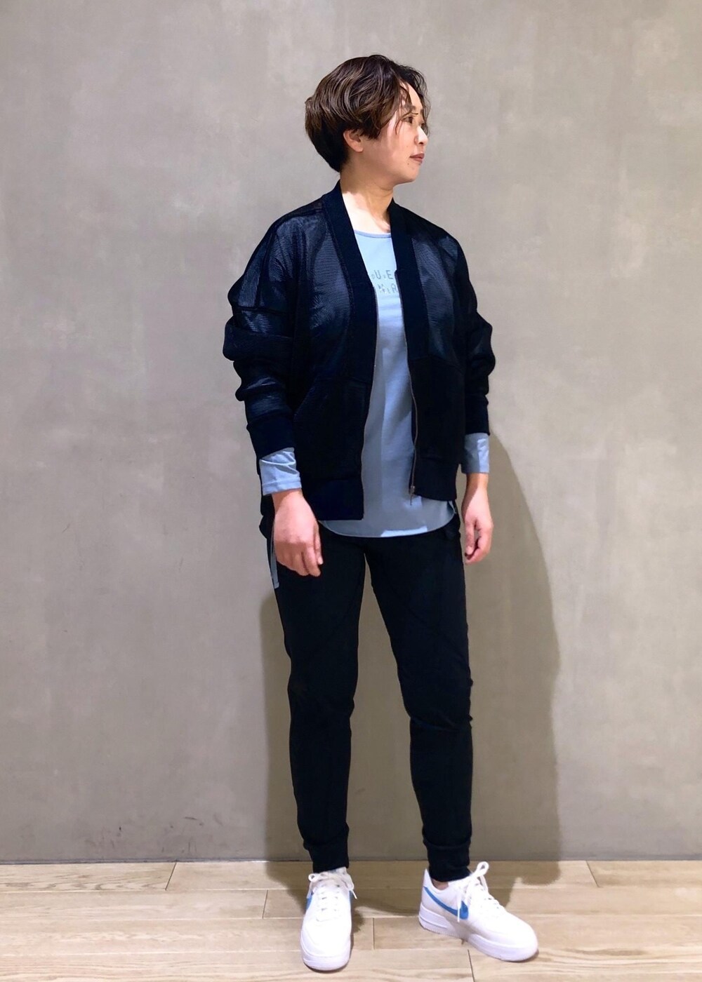 ブラック系のカーディガン/ボレロ、ブラック系のTシャツ/カットソー、ホワイト系のスニーカーを着用したレディースの冬コーディネートの2枚目の写真