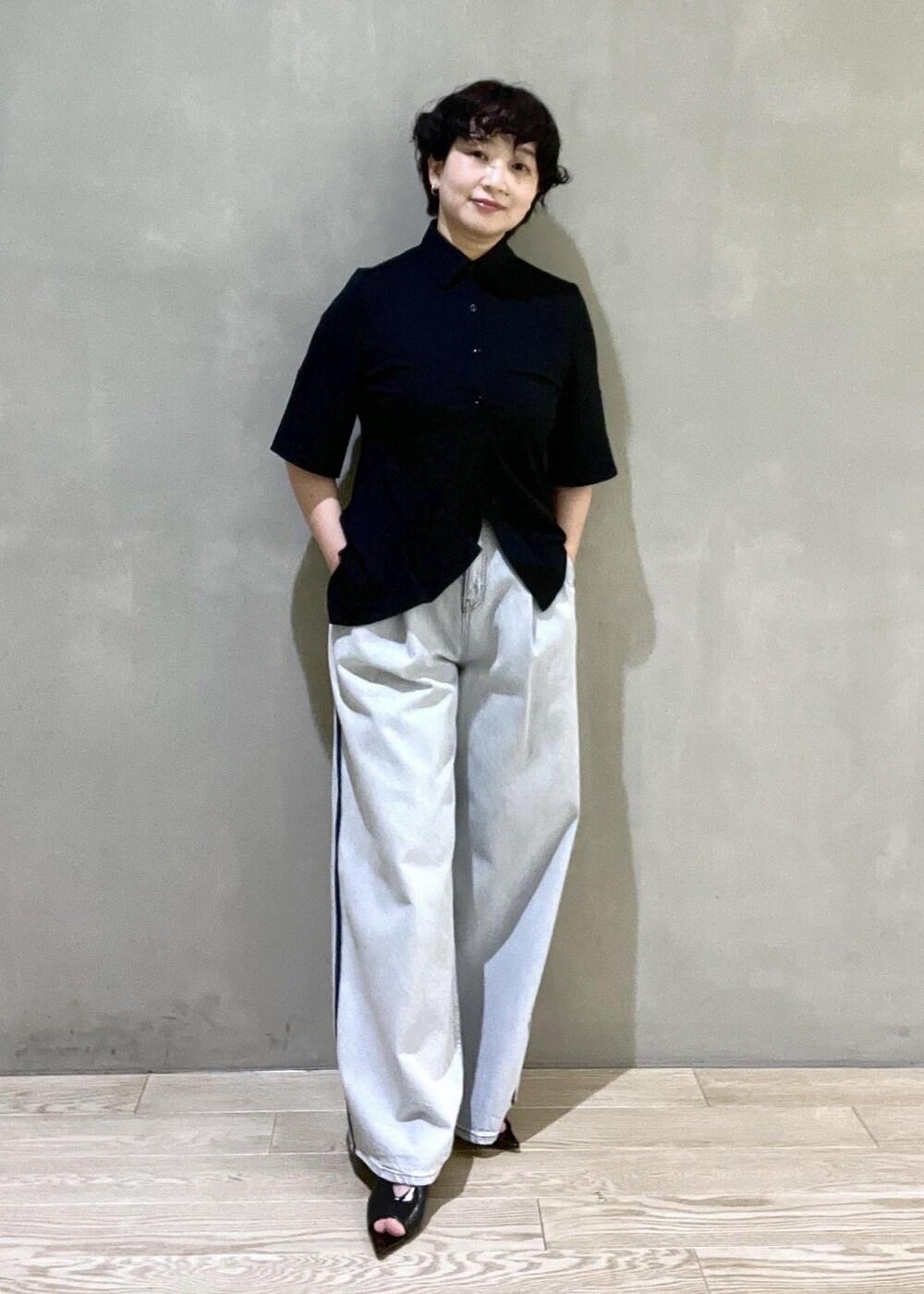 ブルー系のデニムパンツ、ブラック系のシャツ/ブラウス、ブラック系のサンダルを着用したレディースの春コーディネートの4枚目の写真