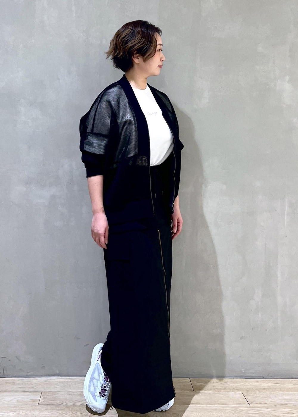 ブラック系のカーディガン/ボレロ、ホワイト系のTシャツ/カットソー、グリーン系のサンダルを着用したレディースの春コーディネートの2枚目の写真