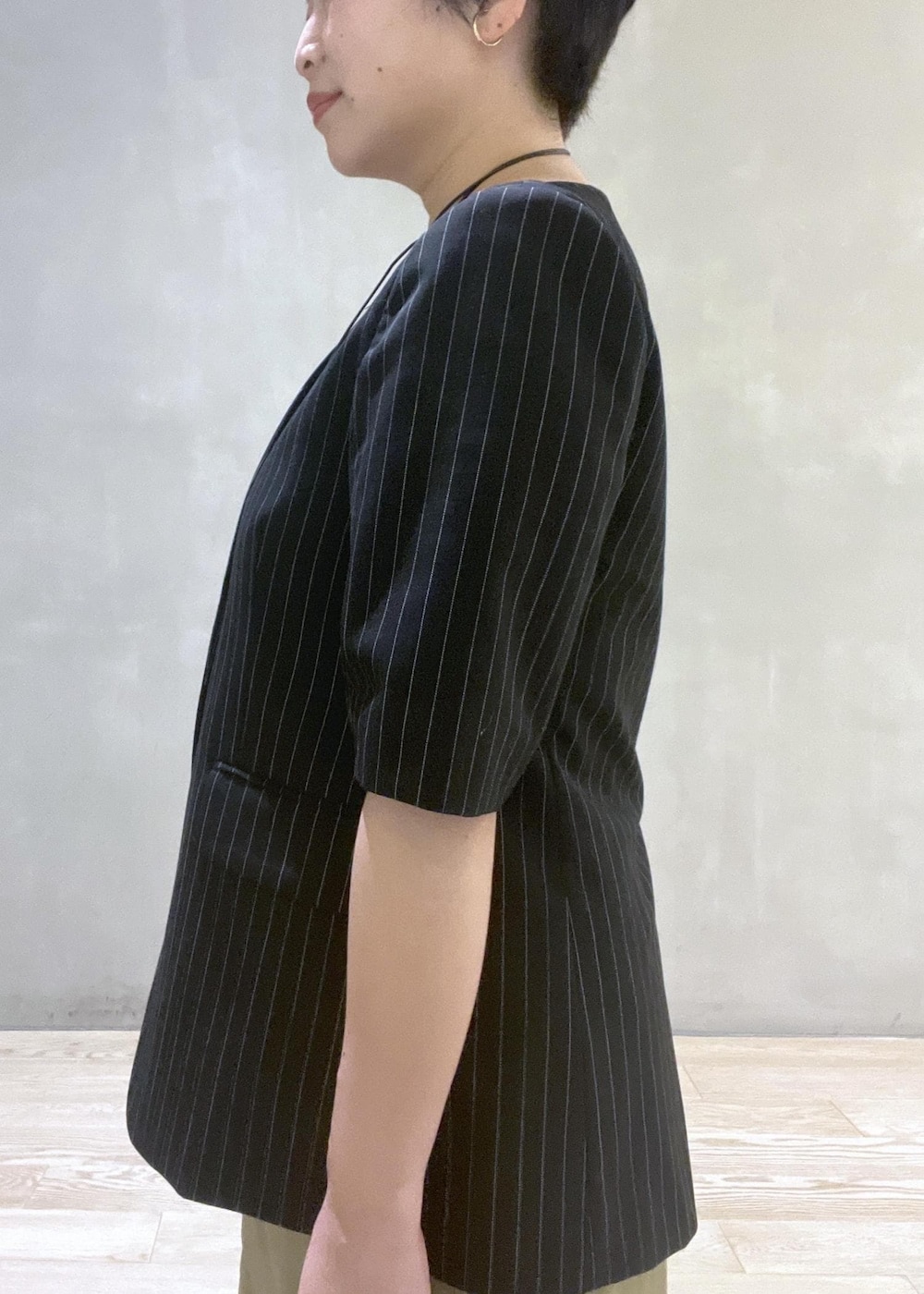 ブラック系のハンドバッグ、ブラック系のノーカラージャケット、ブラック系のサンダルを着用したレディースの夏コーディネートの5枚目の写真