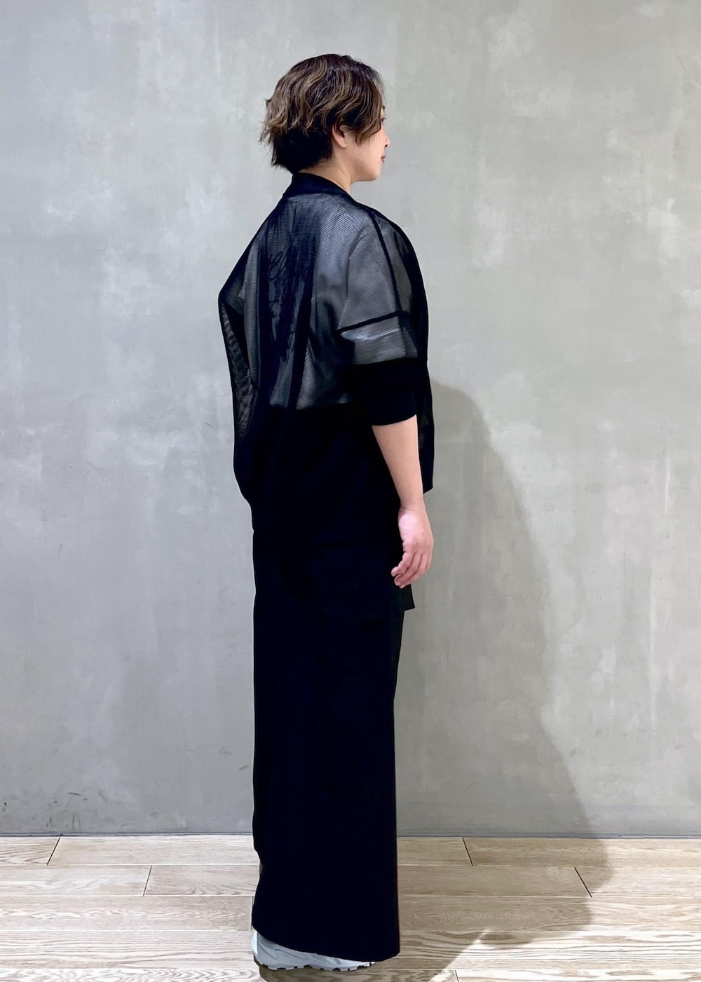 ブラック系のカーディガン/ボレロ、ホワイト系のTシャツ/カットソー、グリーン系のサンダルを着用したレディースの春コーディネートの3枚目の写真