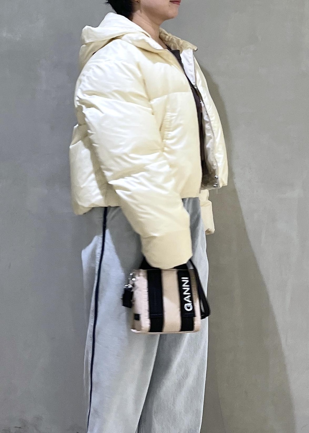 ベージュ系のトートバッグ、ブルー系のデニムパンツ、ブラウン系のスウェットを着用したレディースの秋コーディネートの5枚目の写真