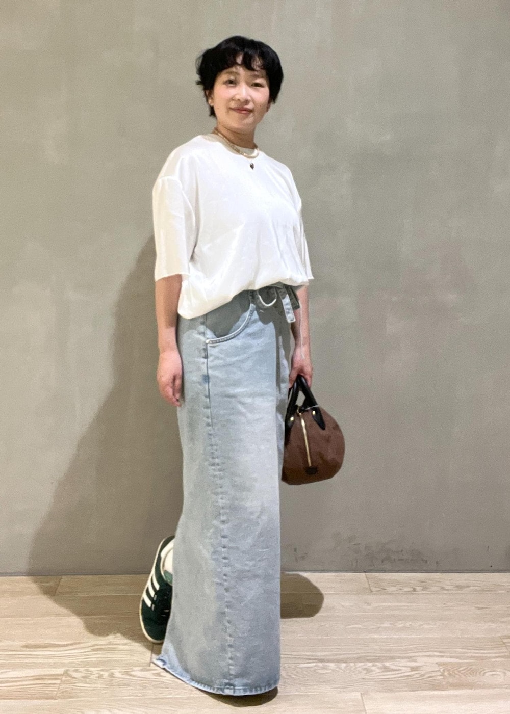 ブラウン系のハンドバッグ、ホワイト系のシャツ/ブラウスを着用したレディースの夏コーディネートの5枚目の写真