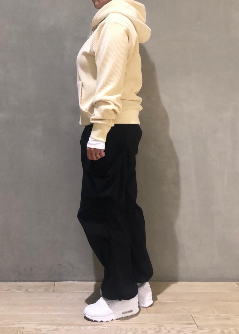 ホワイト系のパーカー、ブラック系のその他パンツを着用したレディースの冬コーディネートの2枚目の写真