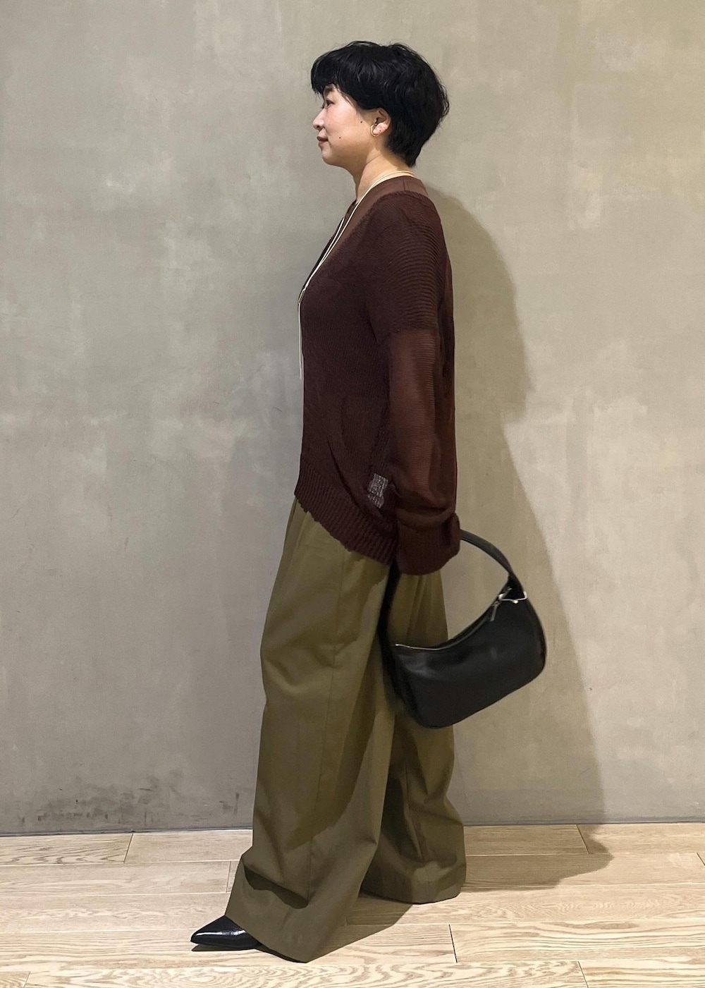 ブラック系のハンドバッグ、グリーン系のその他パンツ、ブラウン系のTシャツ/カットソーを着用したレディースの夏コーディネートの2枚目の写真