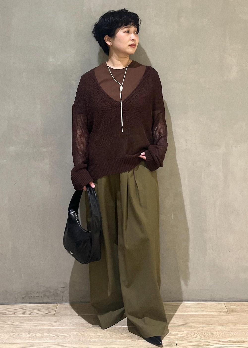 ブラック系のハンドバッグ、グリーン系のその他パンツ、ブラウン系のTシャツ/カットソーを着用したレディースの夏コーディネートの6枚目の写真