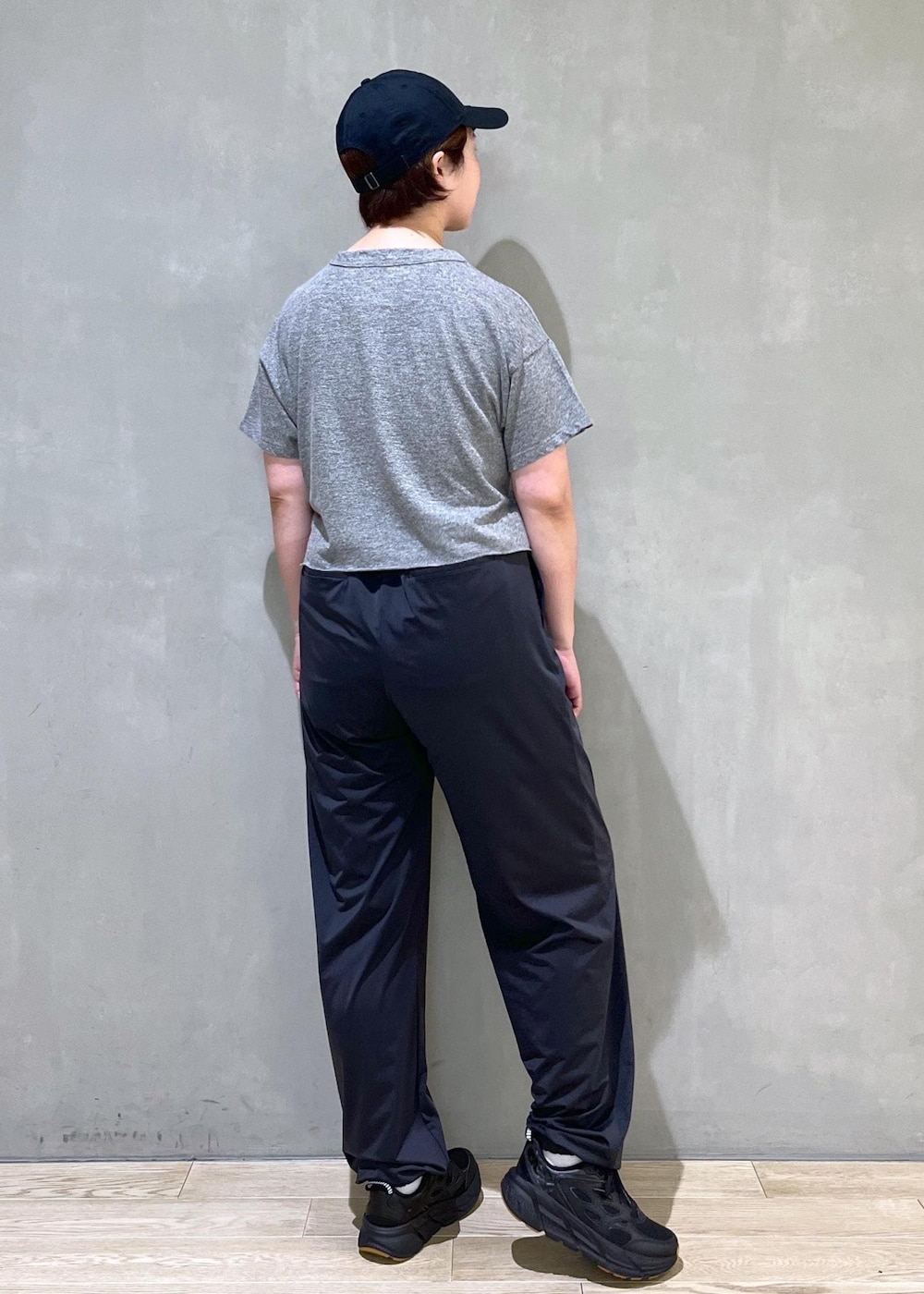 ブラック系のカーゴパンツ、ブラック系のスニーカー、ブラック系のキャップを着用したレディースの夏コーディネートの3枚目の写真