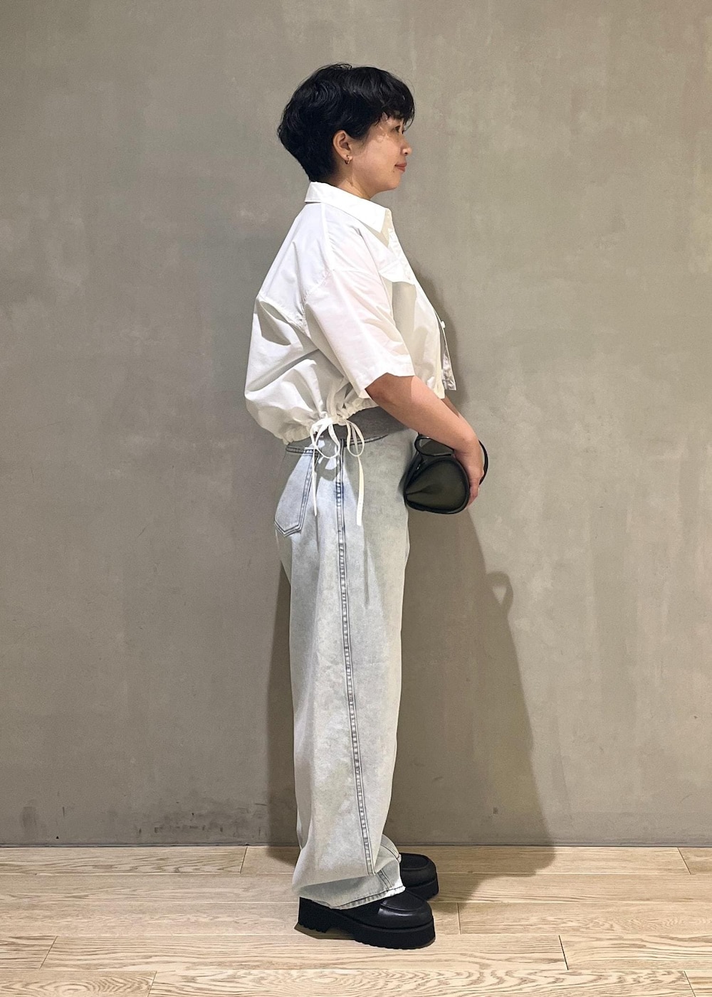 グレー系のTシャツ/カットソー、ブルー系のデニムパンツ、ホワイト系のシャツ/ブラウスを着用したレディースの夏コーディネートの2枚目の写真
