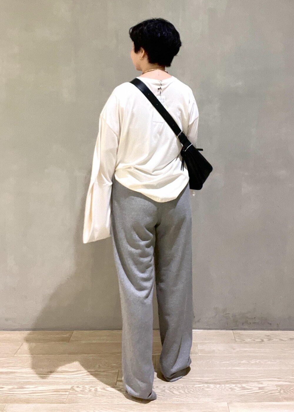 ブラック系のショルダーバッグ、ホワイト系のTシャツ/カットソー、ホワイト系のパンプスを着用したレディースの夏コーディネートの6枚目の写真