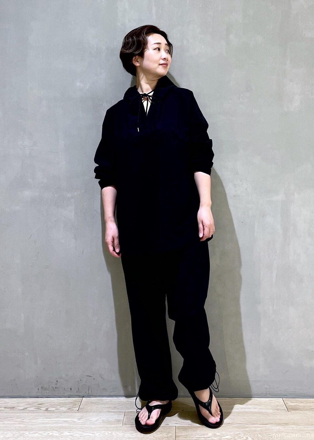 ブラック系のその他パンツ、ブラック系のサンダル、ブラック系のパーカーを着用したレディースの春コーディネートの3枚目の写真