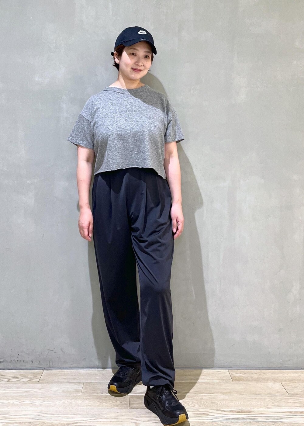 ブラック系のカーゴパンツ、ブラック系のスニーカー、ブラック系のキャップを着用したレディースの夏コーディネートの2枚目の写真