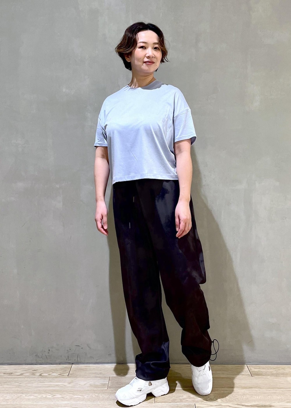 ブラック系のその他パンツ、ホワイト系のスニーカー、ブルー系のTシャツ/カットソーを着用したレディースの春コーディネートの3枚目の写真