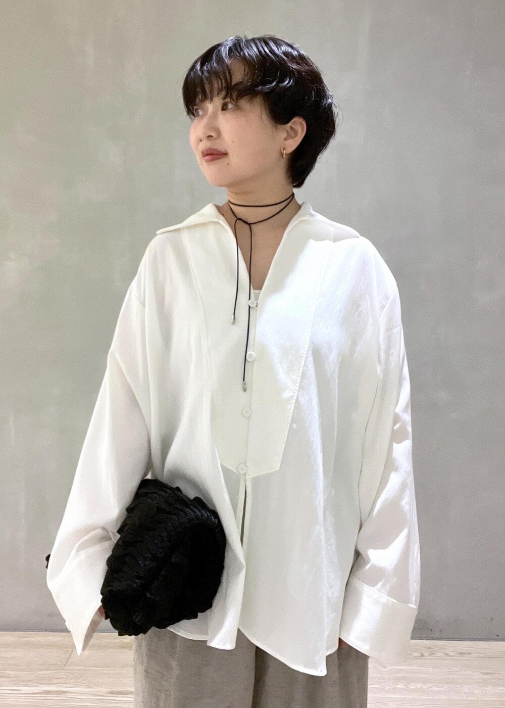 ブラック系のハンドバッグ、ホワイト系のシャツ/ブラウス、ベージュ系のその他パンツを着用したレディースの春コーディネートの5枚目の写真