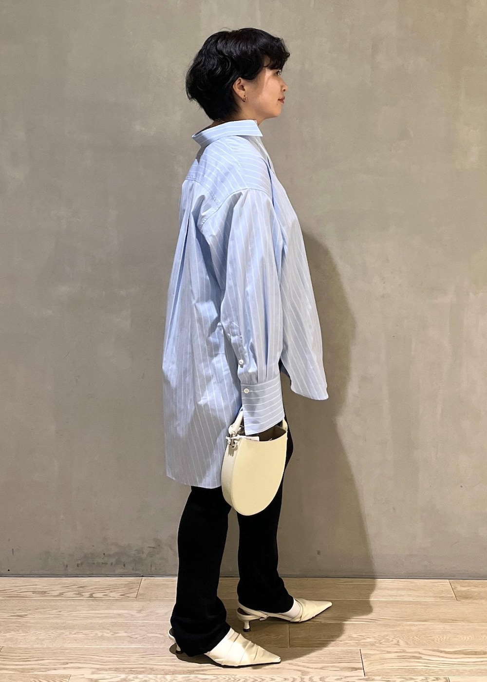ブラック系のその他パンツ、ホワイト系のショルダーバッグ、ブルー系のシャツ/ブラウスを着用したレディースの夏コーディネートの2枚目の写真