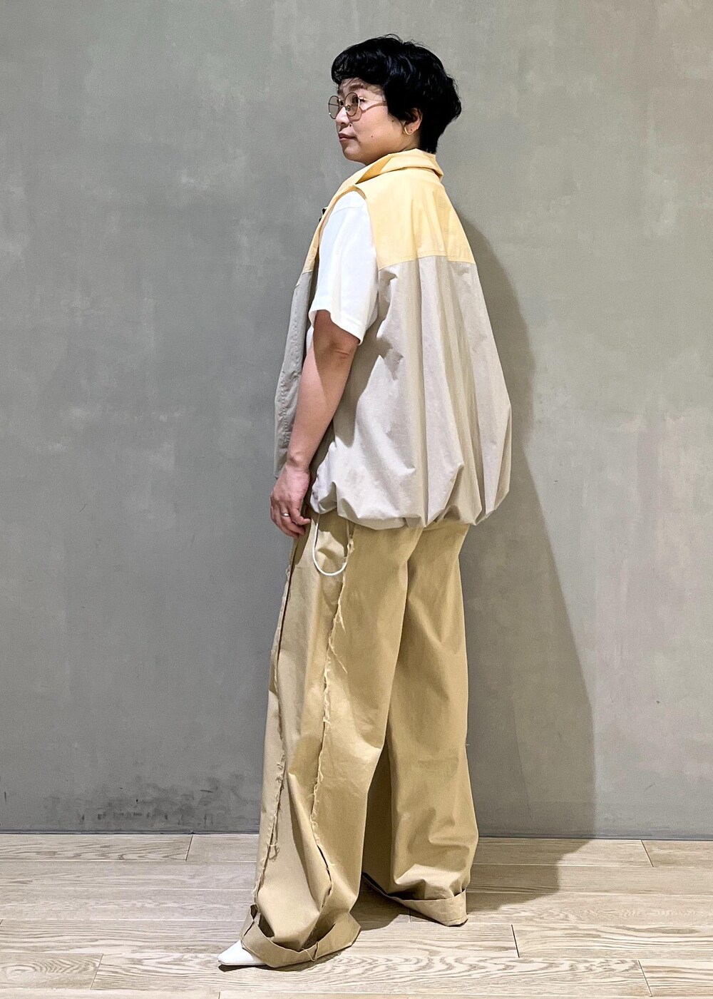 グレー系のハンドバッグ、ホワイト系のTシャツ/カットソー、ベージュ系のブルゾンを着用したレディースの夏コーディネートの3枚目の写真