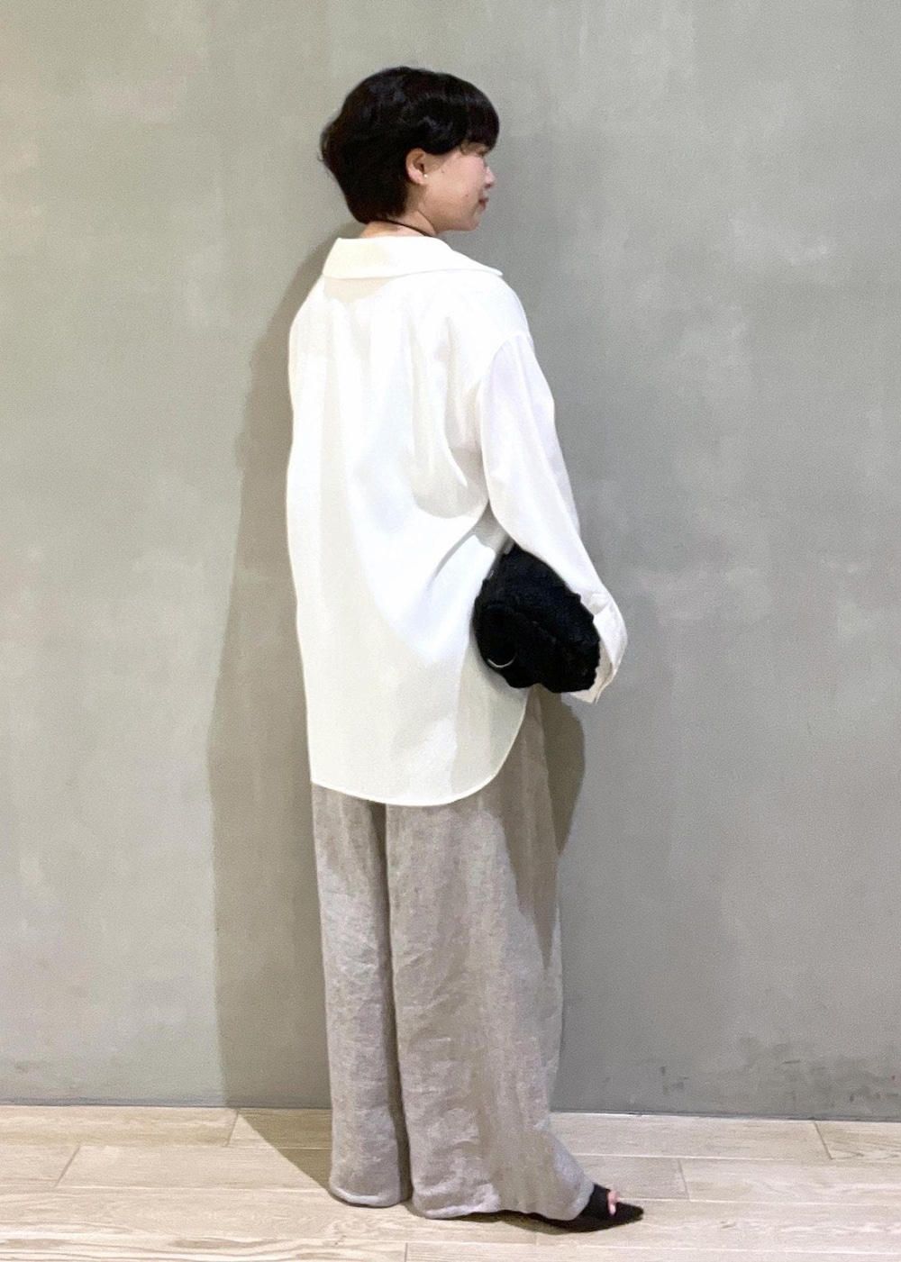 ブラック系のハンドバッグ、ホワイト系のシャツ/ブラウス、ベージュ系のその他パンツを着用したレディースの春コーディネートの4枚目の写真