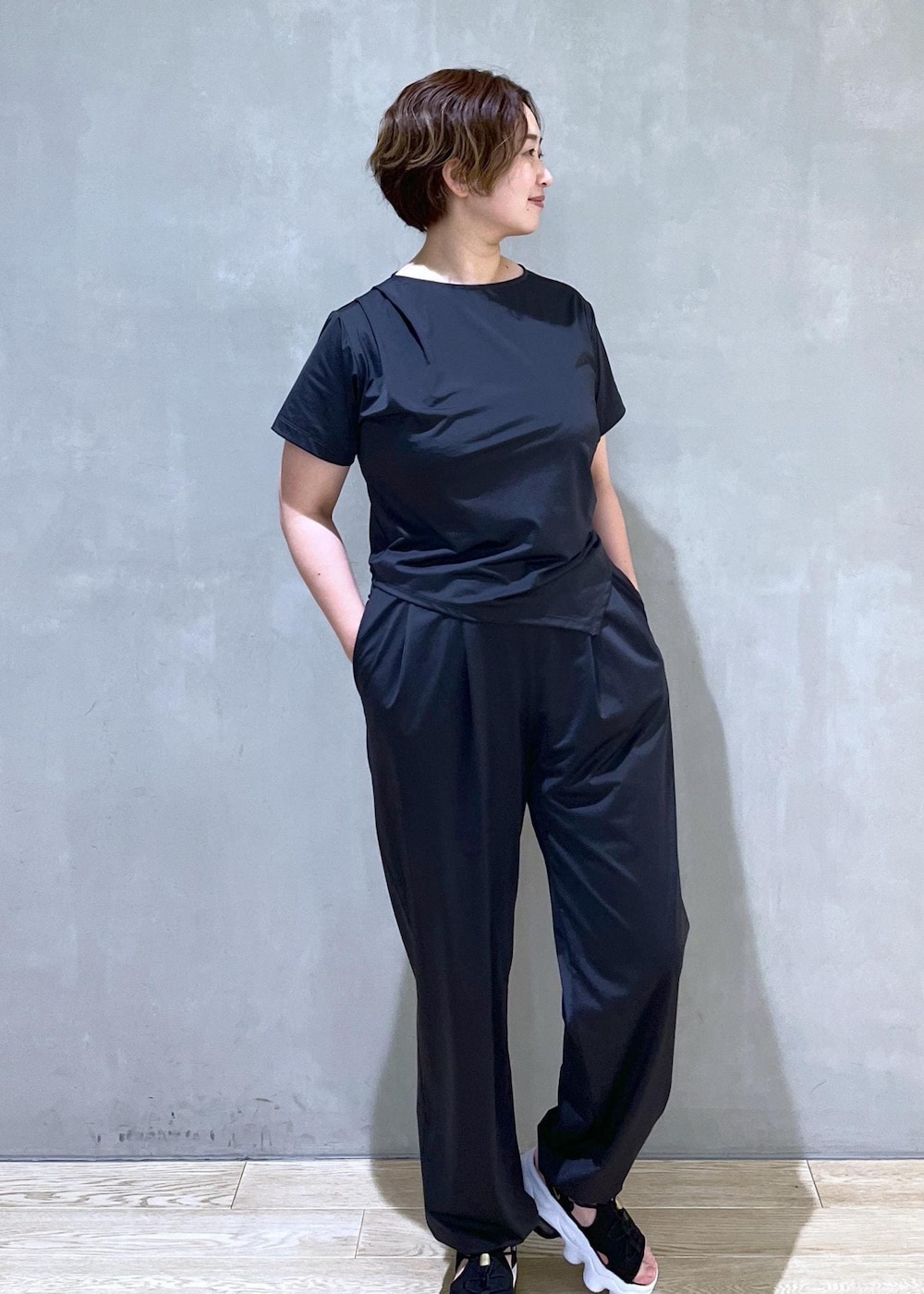 ブラック系のサンダル、ブラック系のTシャツ/カットソー、ブラック系のカーゴパンツを着用したレディースの春コーディネートの2枚目の写真