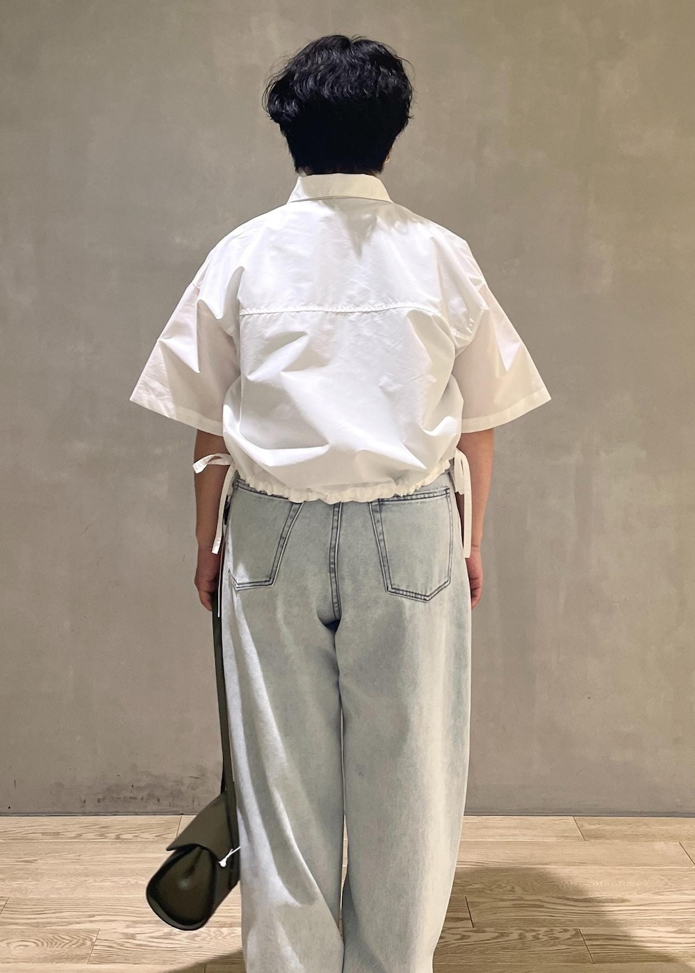 グレー系のTシャツ/カットソー、ブルー系のデニムパンツ、ホワイト系のシャツ/ブラウスを着用したレディースの夏コーディネートの3枚目の写真
