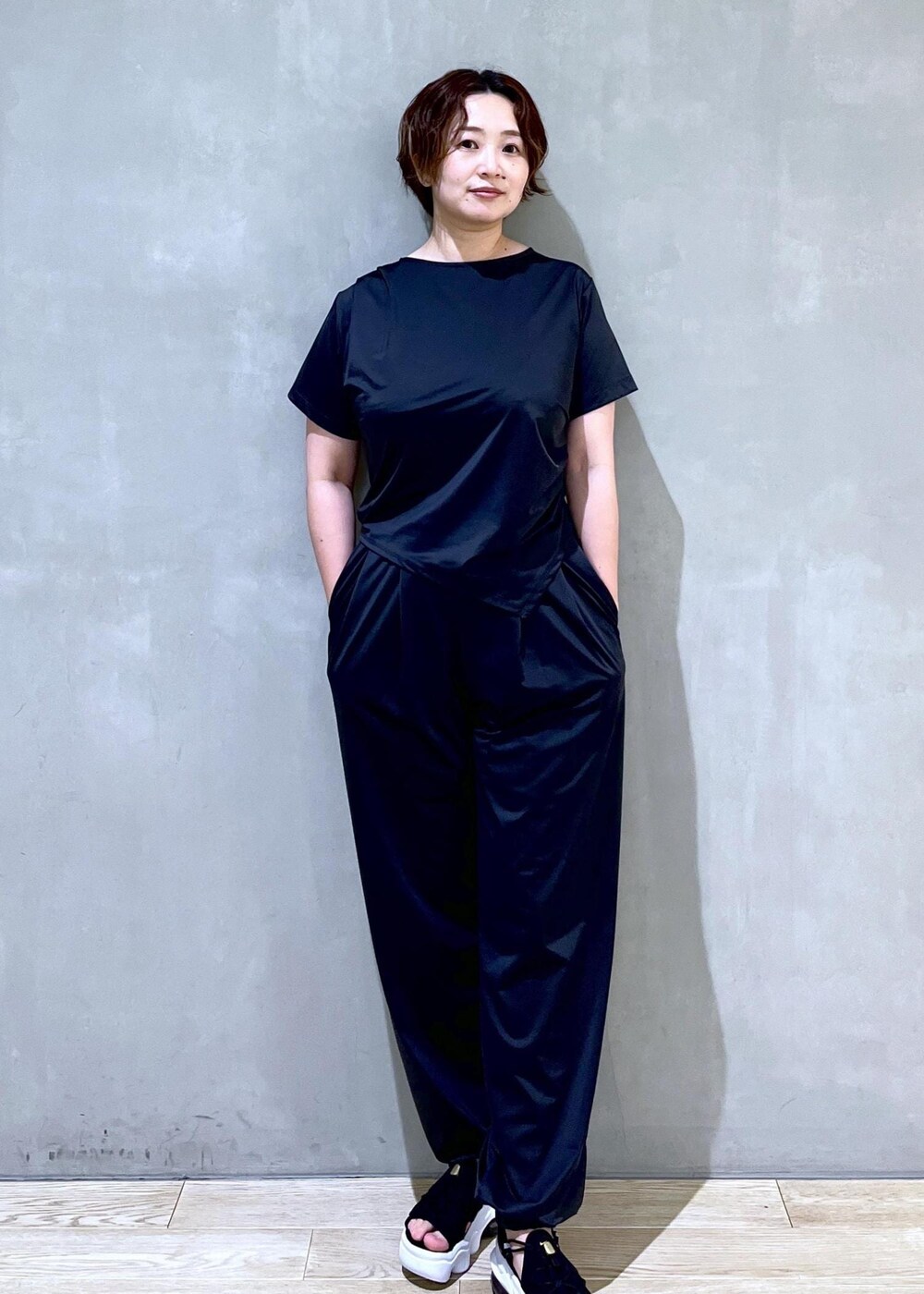 ブラック系のサンダル、ブラック系のTシャツ/カットソー、ブラック系のカーゴパンツを着用したレディースの春コーディネートの3枚目の写真