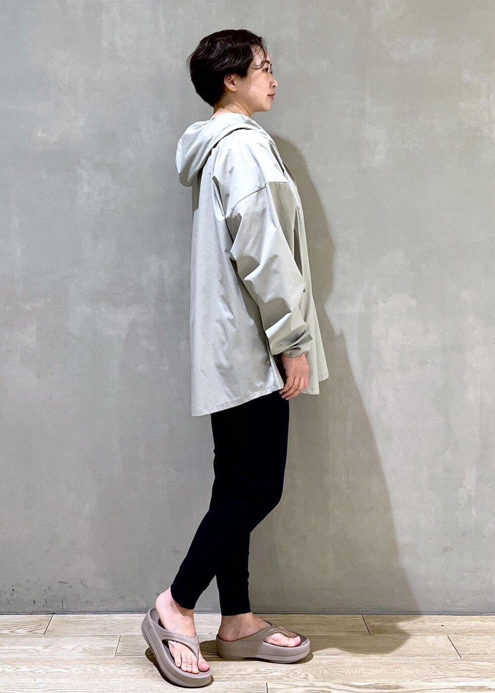 ベージュ系のサンダル、グリーン系のパーカーを着用したレディースの春コーディネートの2枚目の写真