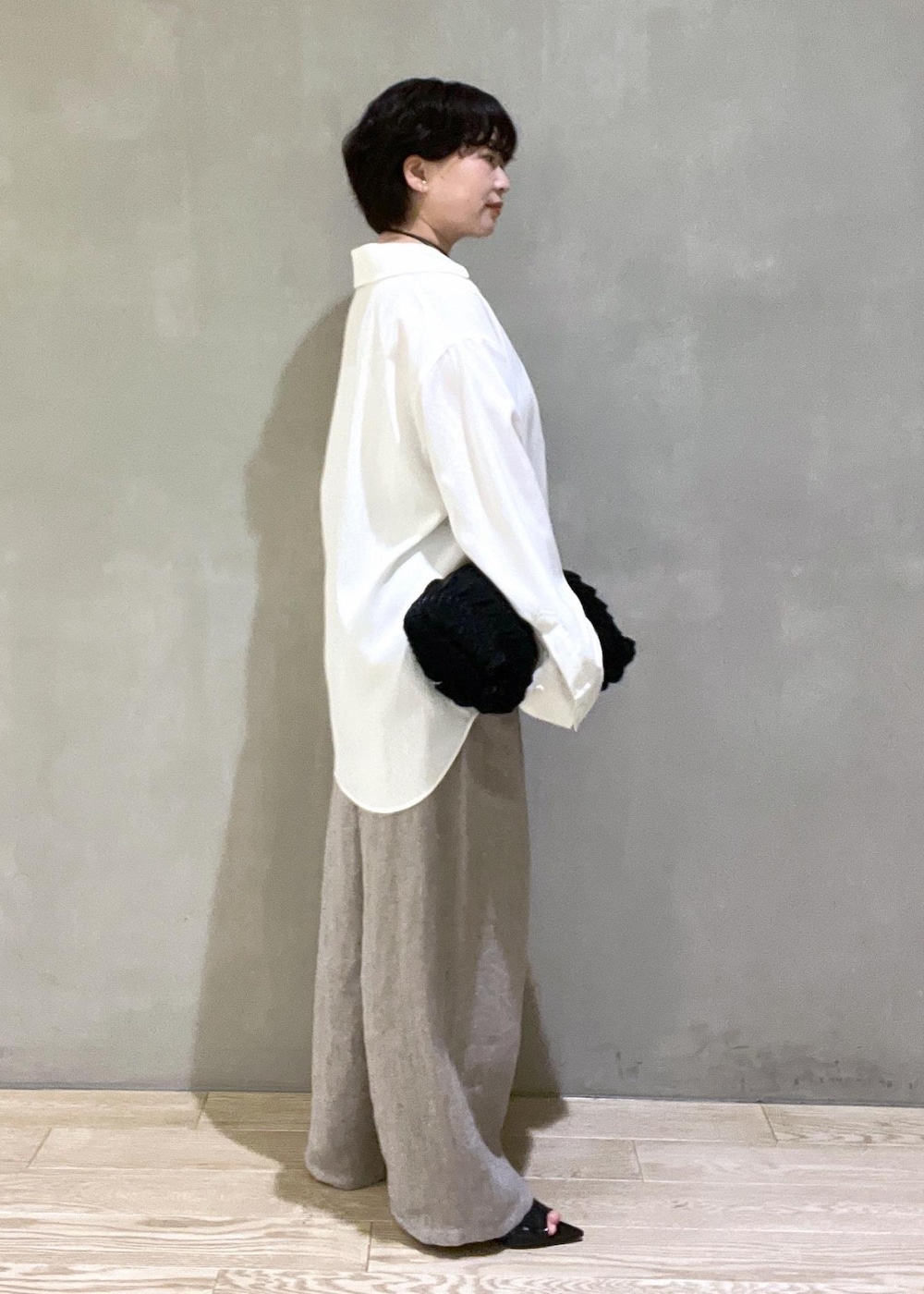 ブラック系のハンドバッグ、ホワイト系のシャツ/ブラウス、ベージュ系のその他パンツを着用したレディースの春コーディネートの3枚目の写真
