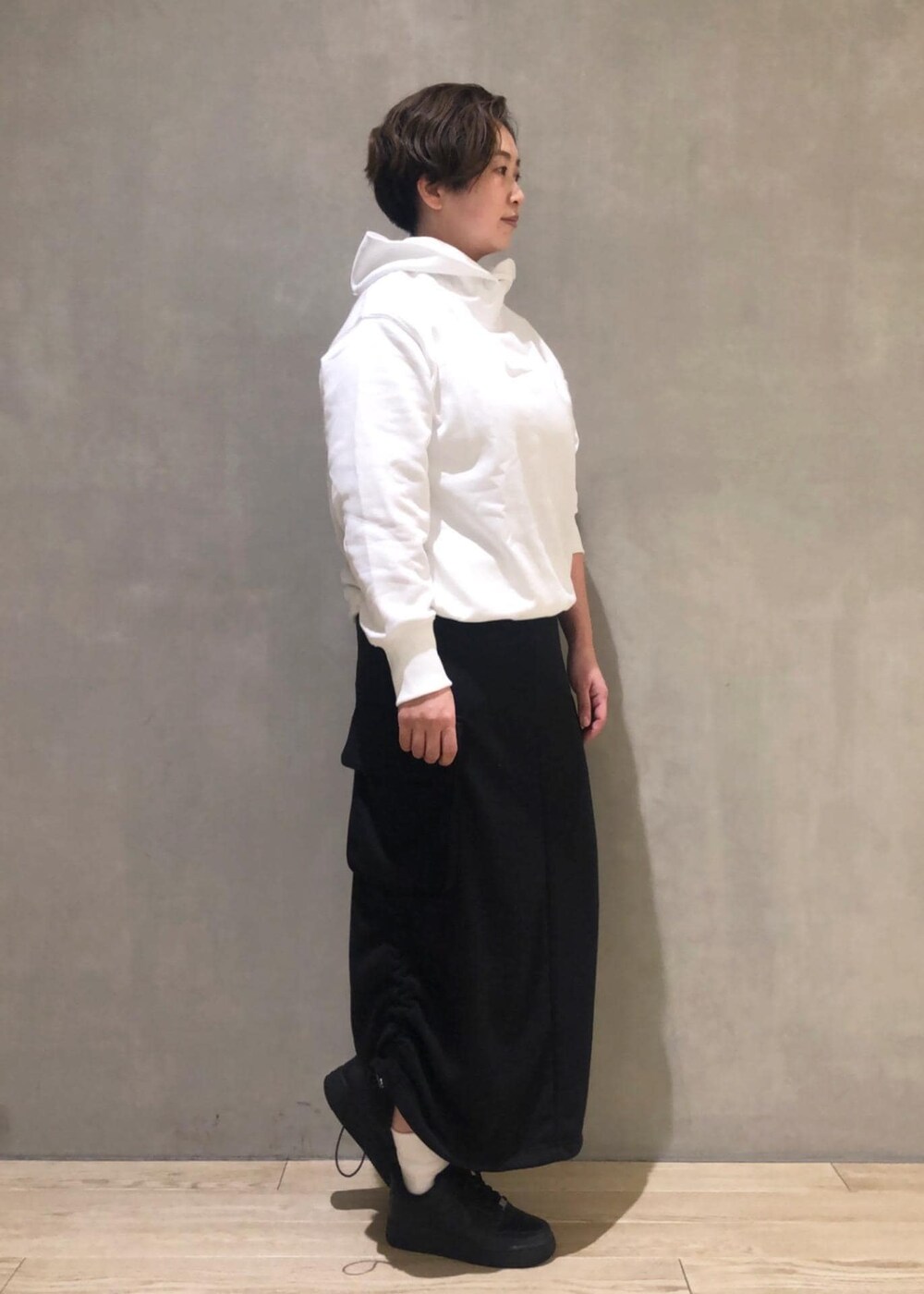 ブラック系のスカート、ブラック系のスニーカーを着用したレディースの冬コーディネートの2枚目の写真