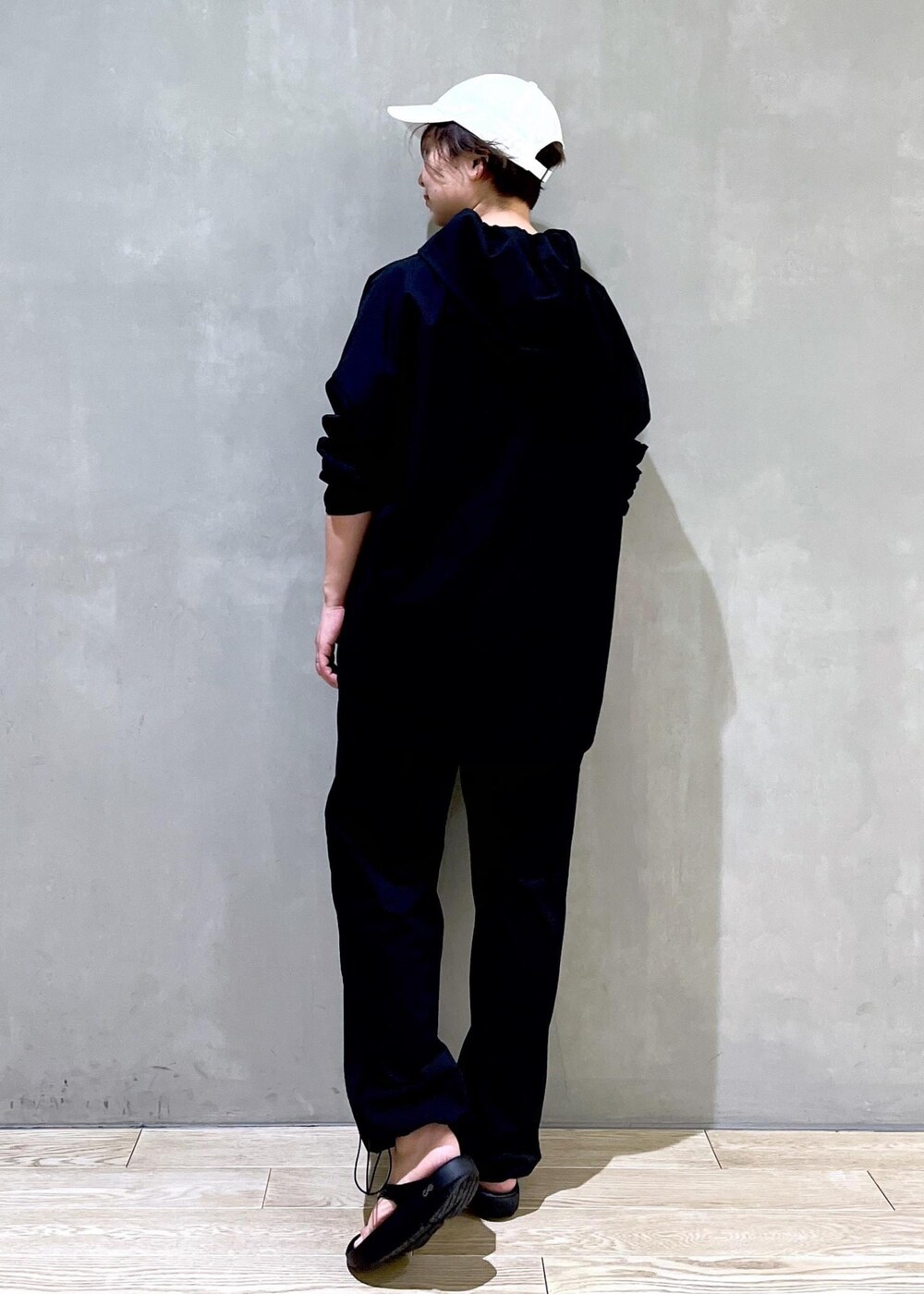 ブラック系のその他パンツ、ブラック系のサンダル、ブラック系のパーカーを着用したレディースの春コーディネートの2枚目の写真