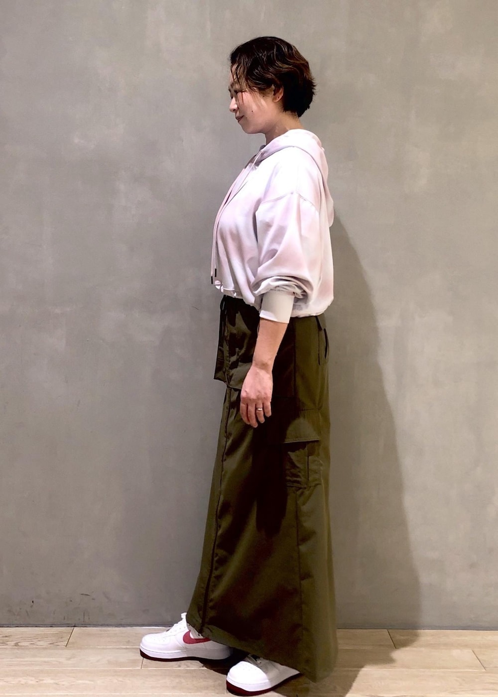 ホワイト系のスニーカー、ピンク系のパーカーを着用したレディースの春コーディネートの2枚目の写真