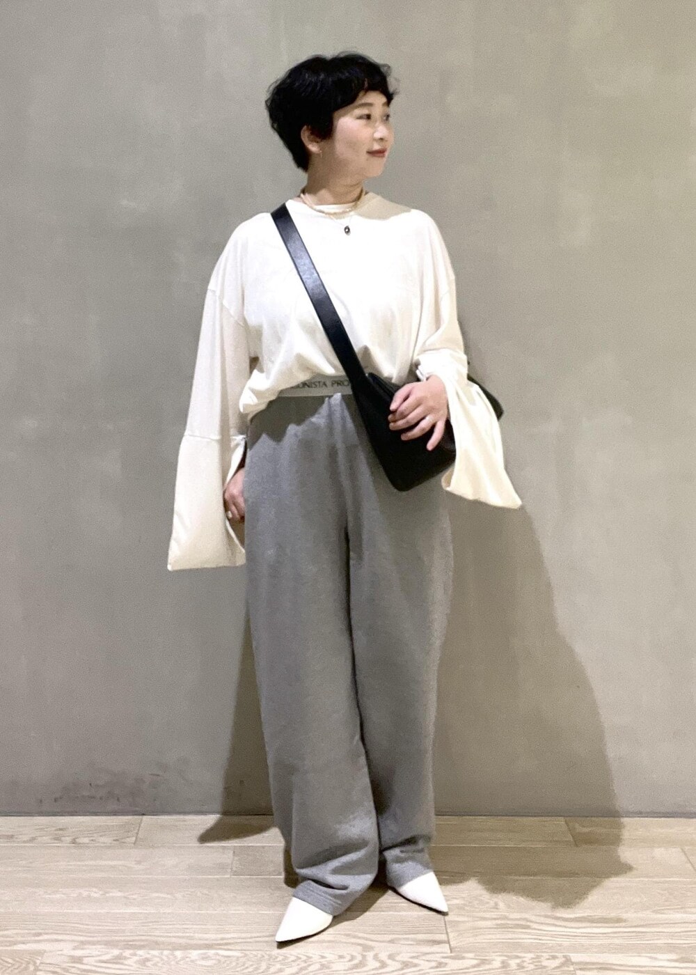ブラック系のショルダーバッグ、ホワイト系のTシャツ/カットソー、ホワイト系のパンプスを着用したレディースの夏コーディネートの5枚目の写真