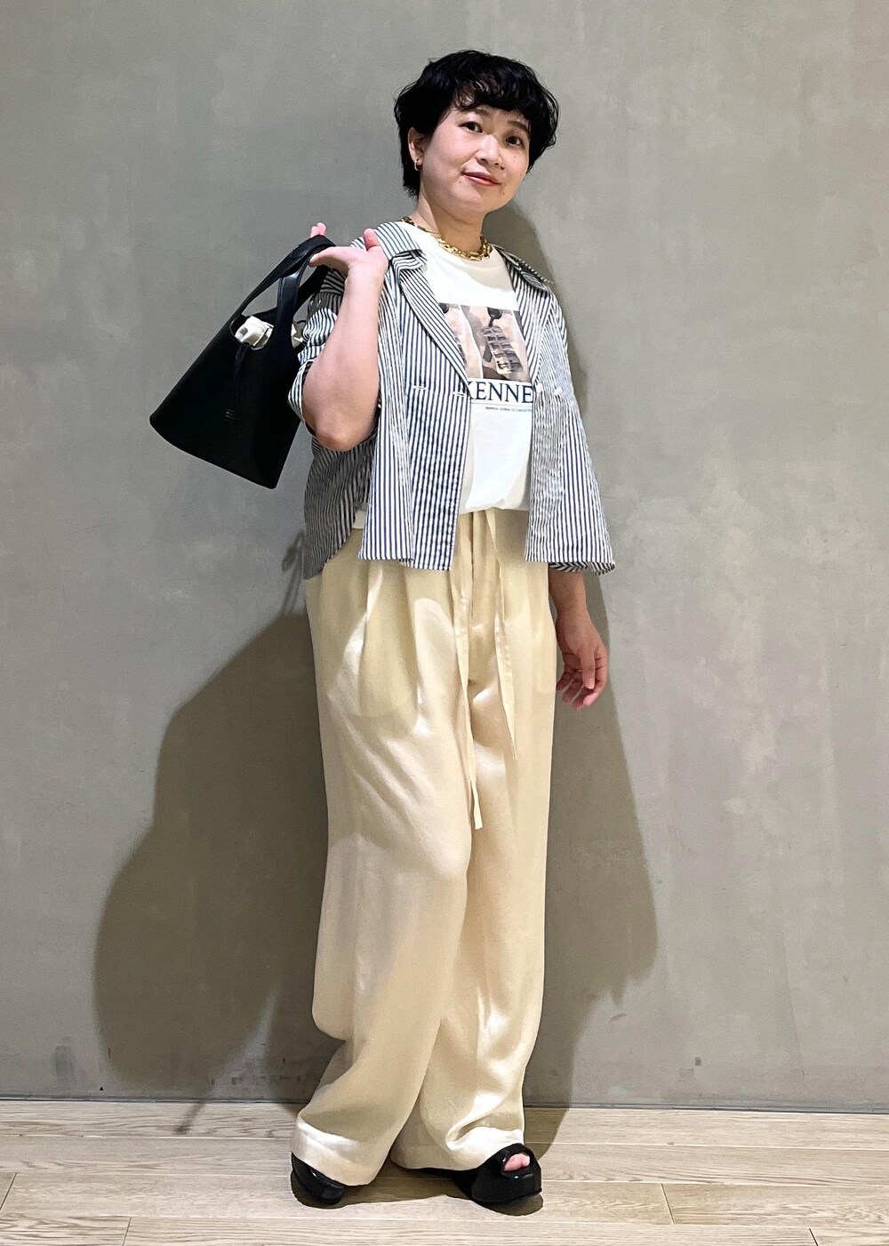 ブラック系のサンダル、ブルー系のシャツ/ブラウス、ホワイト系のスラックスを着用したレディースの夏コーディネートの2枚目の写真