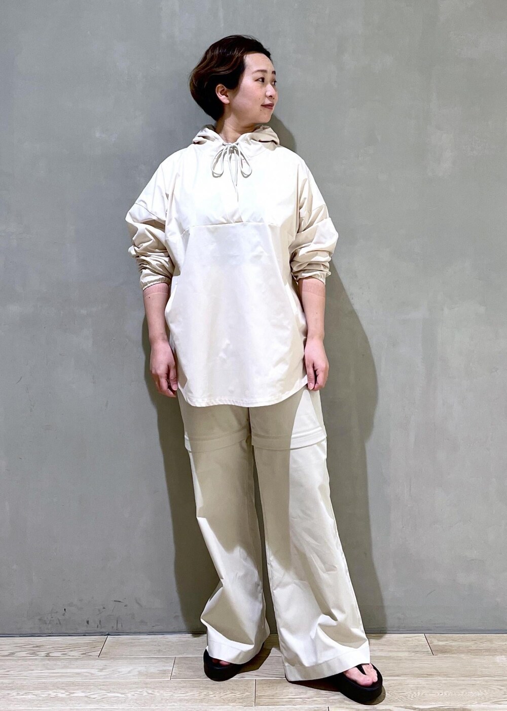 ホワイト系のパーカー、グレー系のその他パンツ、ブラック系のサンダルを着用したレディースの春コーディネートの4枚目の写真