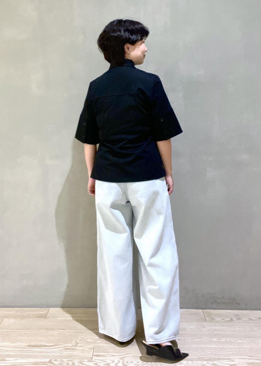 ブルー系のデニムパンツ、ブラック系のシャツ/ブラウス、ブラック系のサンダルを着用したレディースの春コーディネートの2枚目の写真